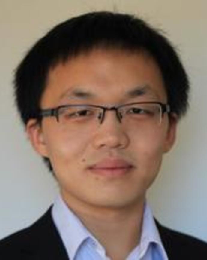 Cheng, smiling at the camera, against a light background